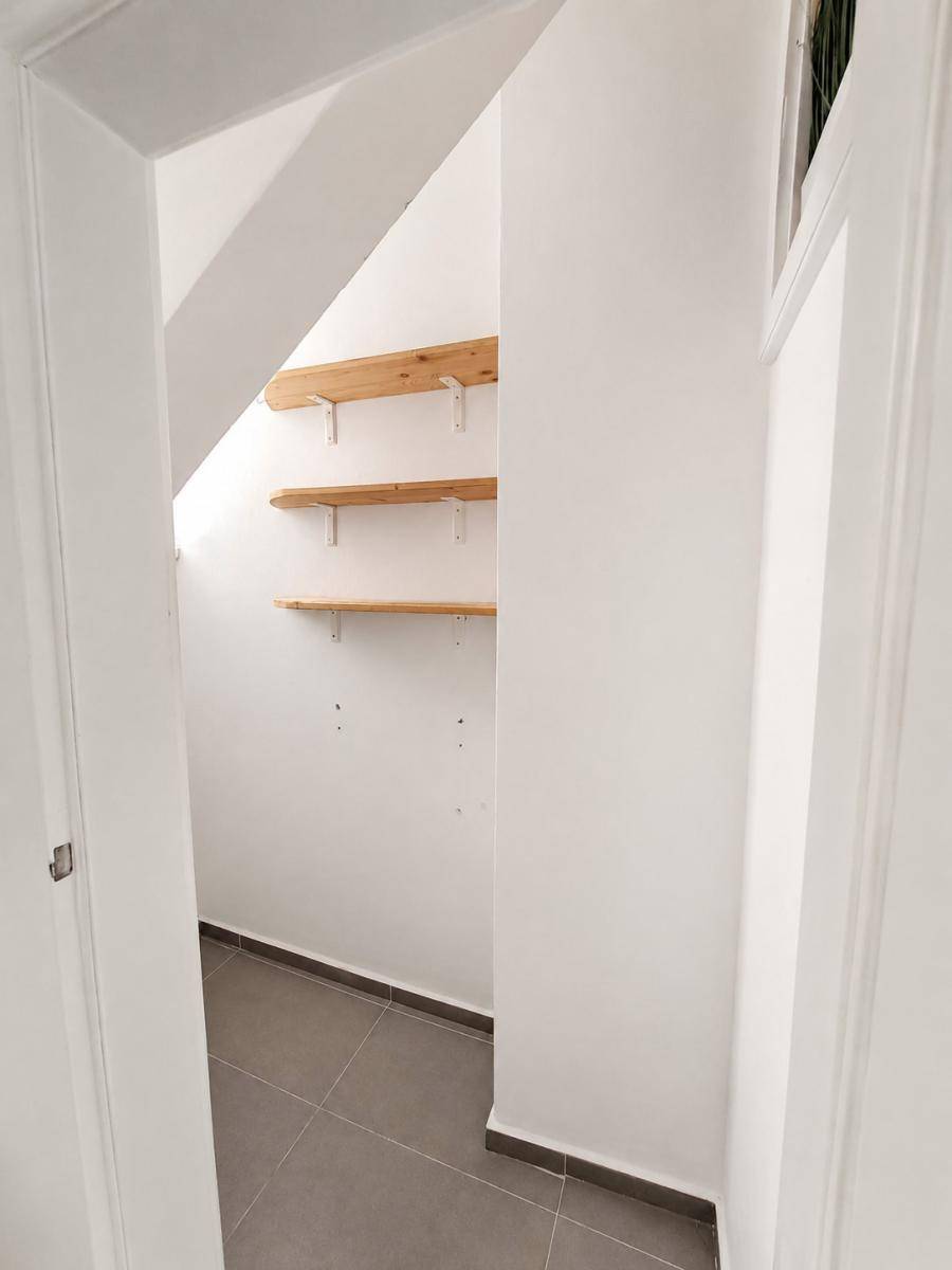 Praktischer Abstellraum mit Holzregalen unter der Dachschräge, ideal für zusätzlichen Stauraum.
