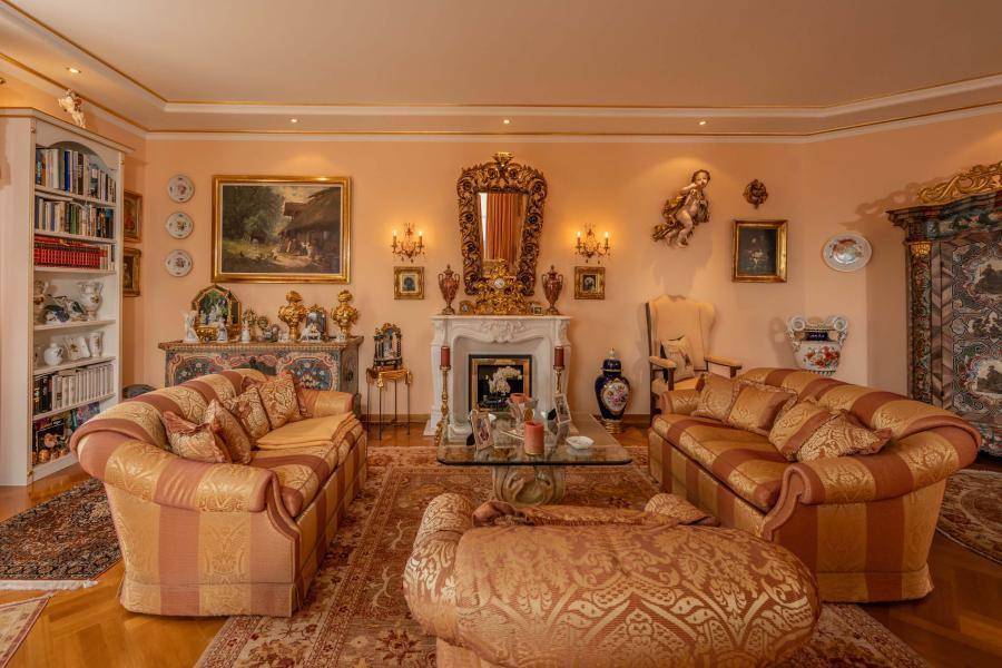 Prunkvolles Wohnzimmer mit Kamin, opulenten Möbeln und goldverzierten Details.