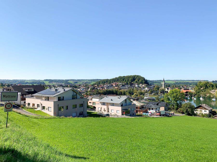 Weitläufiger Blick auf die Ortschaft Mattsee mit See und umliegender Natur.