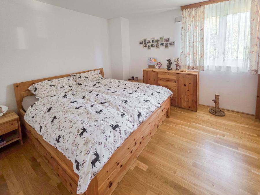 Schlafzimmer mit hellem Holzbett, passenden Nachttischen und Parkettboden.