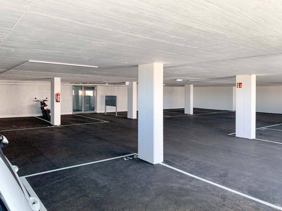 Geräumige Tiefgarage mit vielen Parkplätzen und klaren Markierungen.