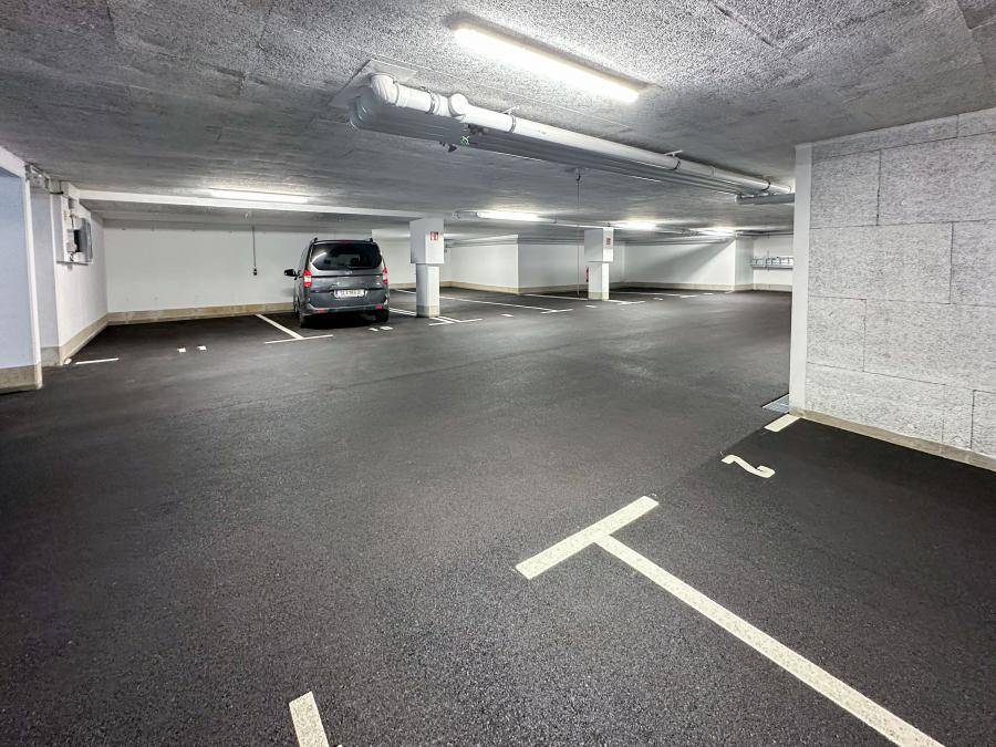 Saubere Tiefgarage mit vielen freien Stellplätzen und einem geparkten Fahrzeug.