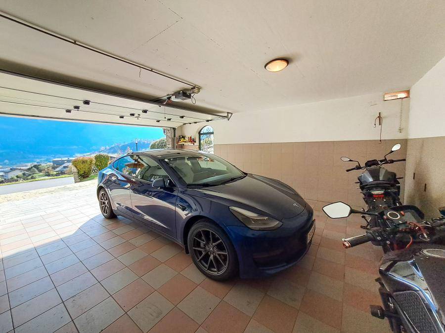 Geräumige Garage mit Fliesenboden und automatischem Tor, bietet Platz für ein Fahrzeug.
