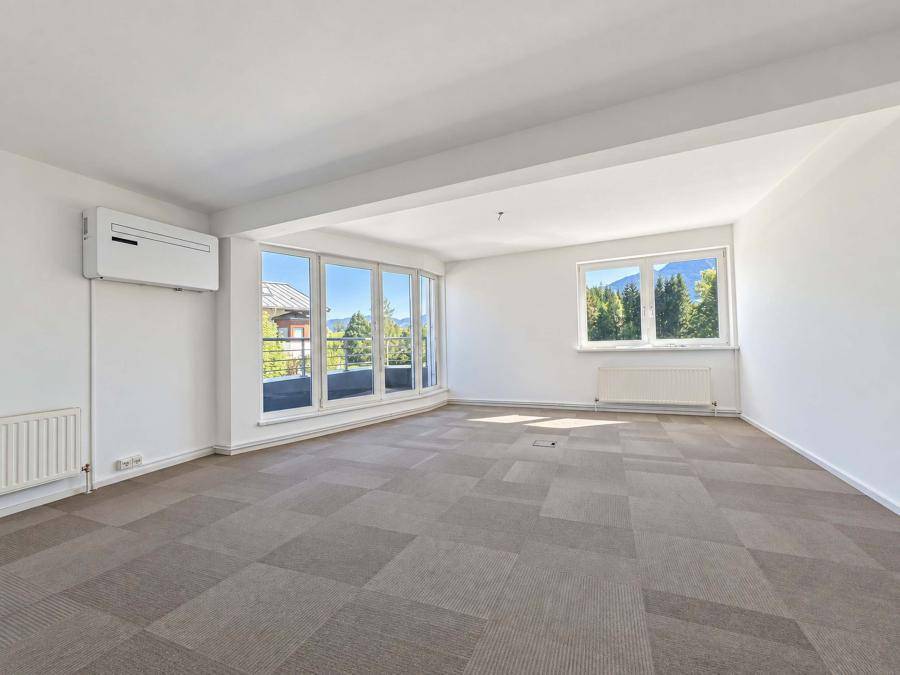 Geräumiges Büro mit Teppichboden, Klimaanlage und großen Fenstern mit Bergblick.