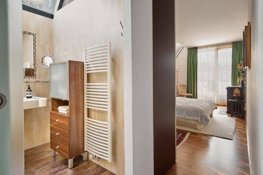 Helles Badezimmer mit Zugang zum Schlafzimmer, ausgestattet mit Handtuchheizkörper und Dachfenster.