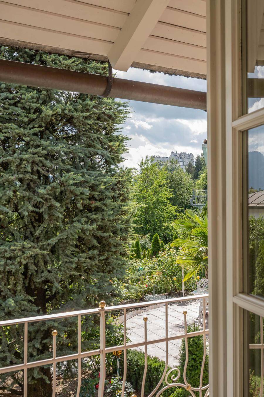 Blick von einem Balkon auf üppiges Grün und die umliegende Landschaft.