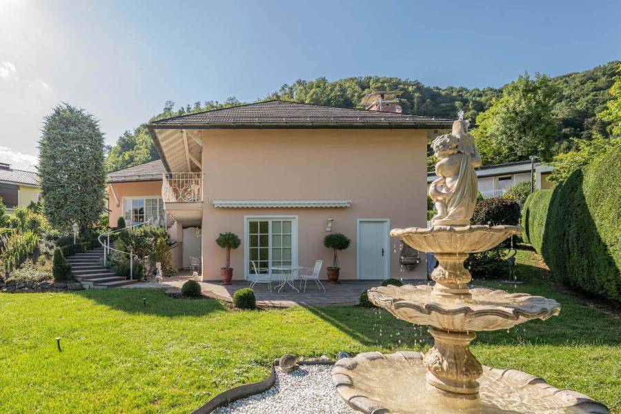 Gepflegter Gartenbereich mit dekorativem Brunnen und Blick auf die Hausfassade.
