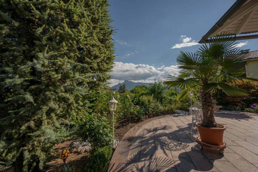 Sonniger Terrassenbereich mit Palmen und weitem Blick auf die umliegende Berglandschaft.