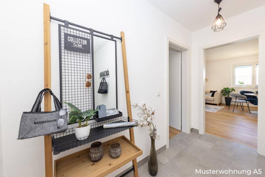 Moderner Eingangsbereich mit Garderobe, Spiegel und Fliesenboden.