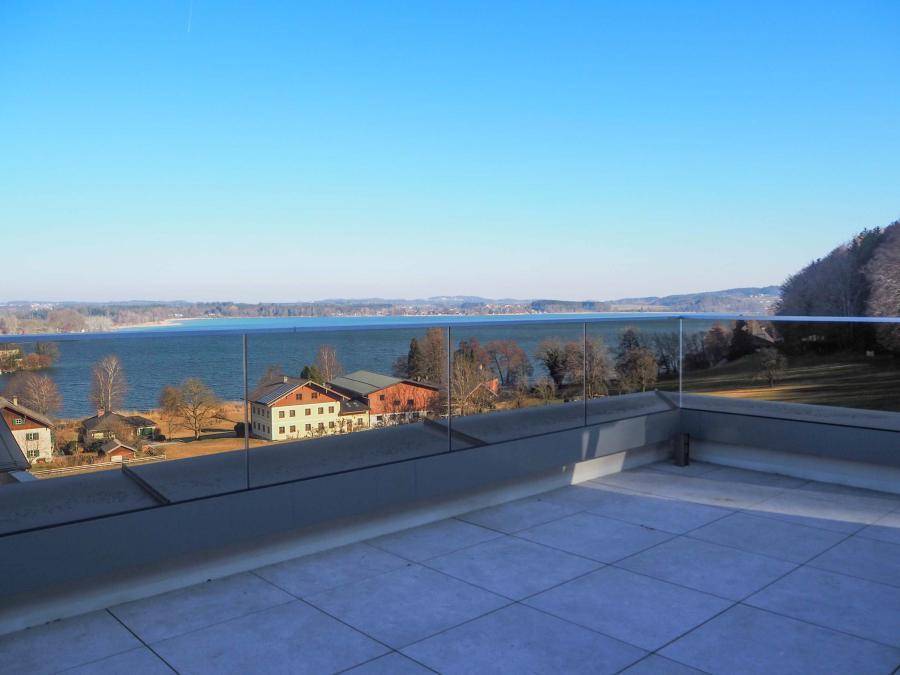 Geräumige Dachterrasse mit Glasgeländer und weitem Blick auf den See und die Landschaft.