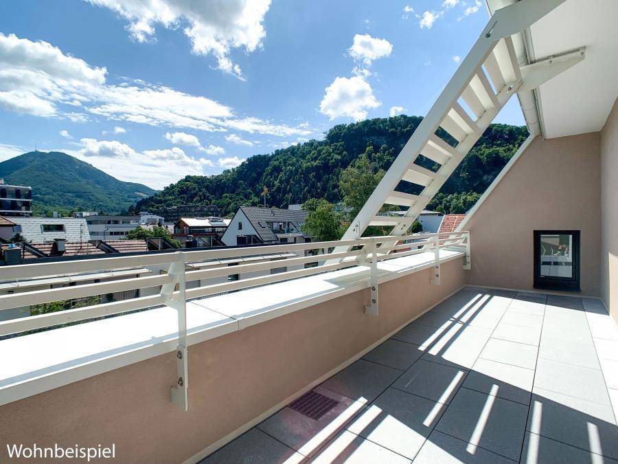Geräumige Terrasse mit Fliesenboden und weitem Blick auf die umliegende Berglandschaft.