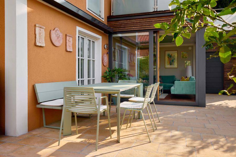 Gemütliche Terrasse mit Gartenmöbeln und direktem Zugang zum Wintergarten des Hauses.