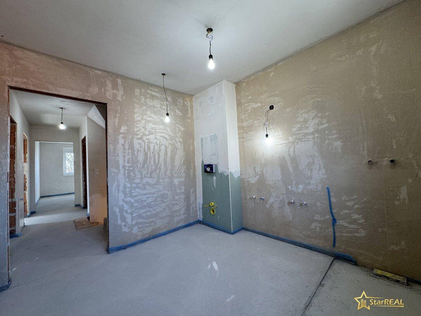 Unfertiges Badezimmer mit Rohinstallationen und Zugang zu weiteren Räumen.