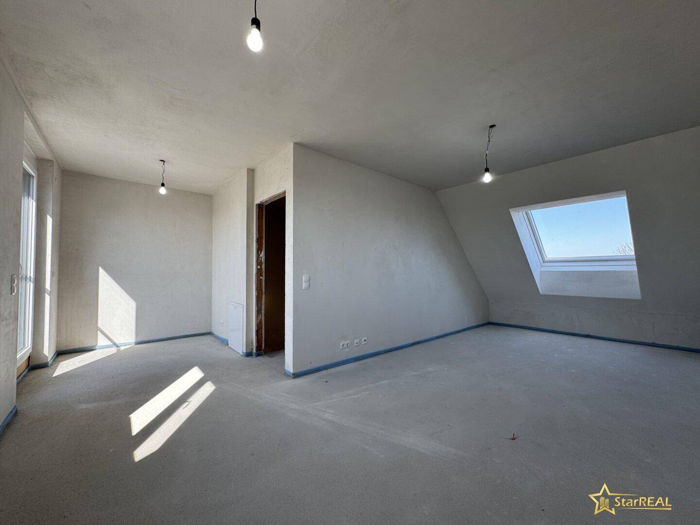 Heller, unfertiger Dachgeschossraum mit Dachfenster und Schrägen, ideal für individuellen Ausbau.