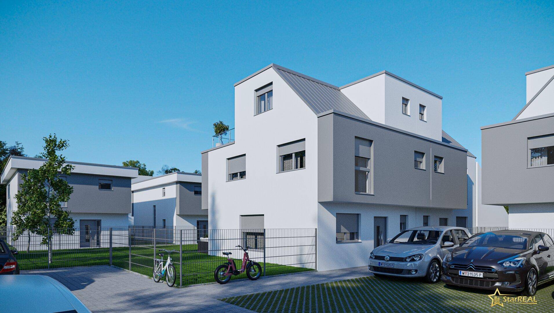 Reihen moderner Häuser mit unterschiedlichen Dachformen und Parkplätzen im Freien.