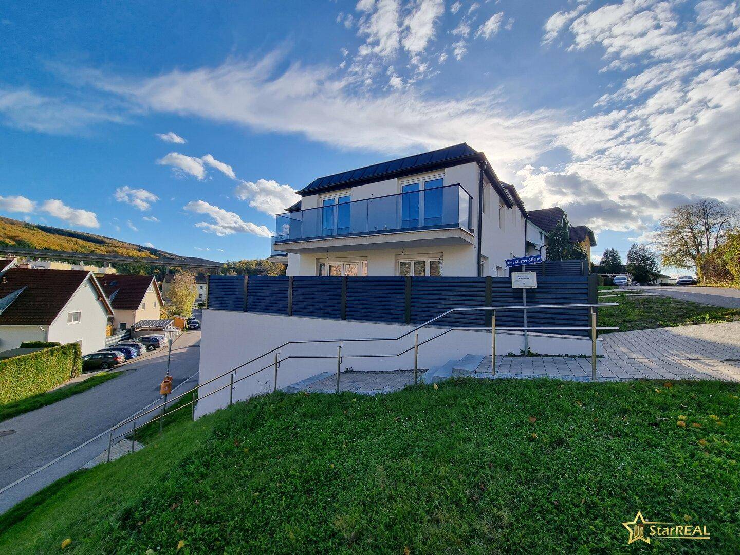 Neubau in Hanglage mit moderner Architektur und Blick auf die umliegende Landschaft.