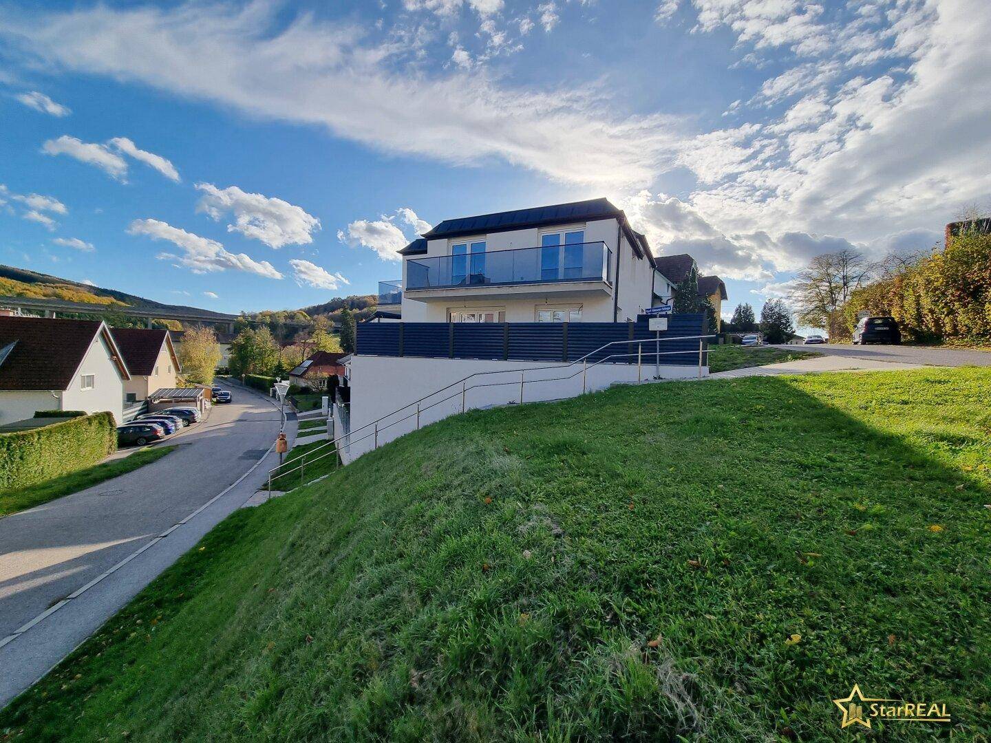 Neubau in Hanglage mit moderner Architektur und Blick auf die umliegende Landschaft.