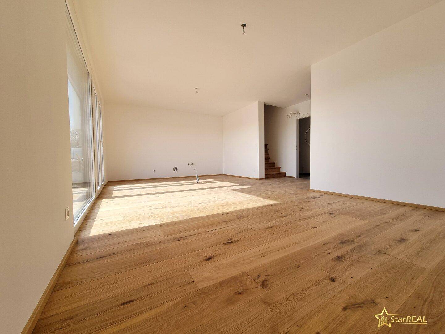 Heller Wohnbereich mit neu verlegtem Eichenparkettboden und viel natürlichem Licht.
