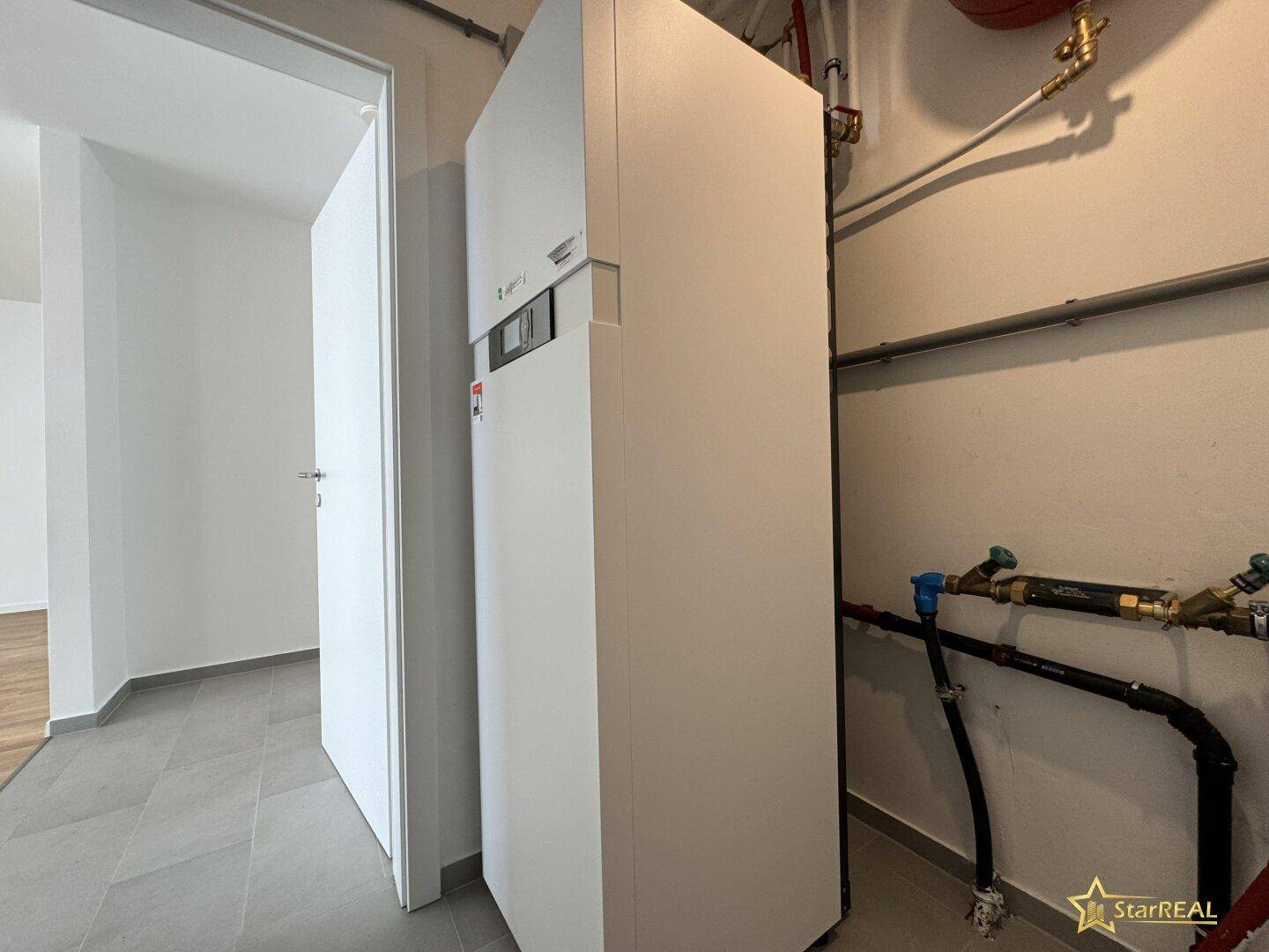 Technikraum mit moderner Heizungsanlage und sichtbaren Rohrleitungen.