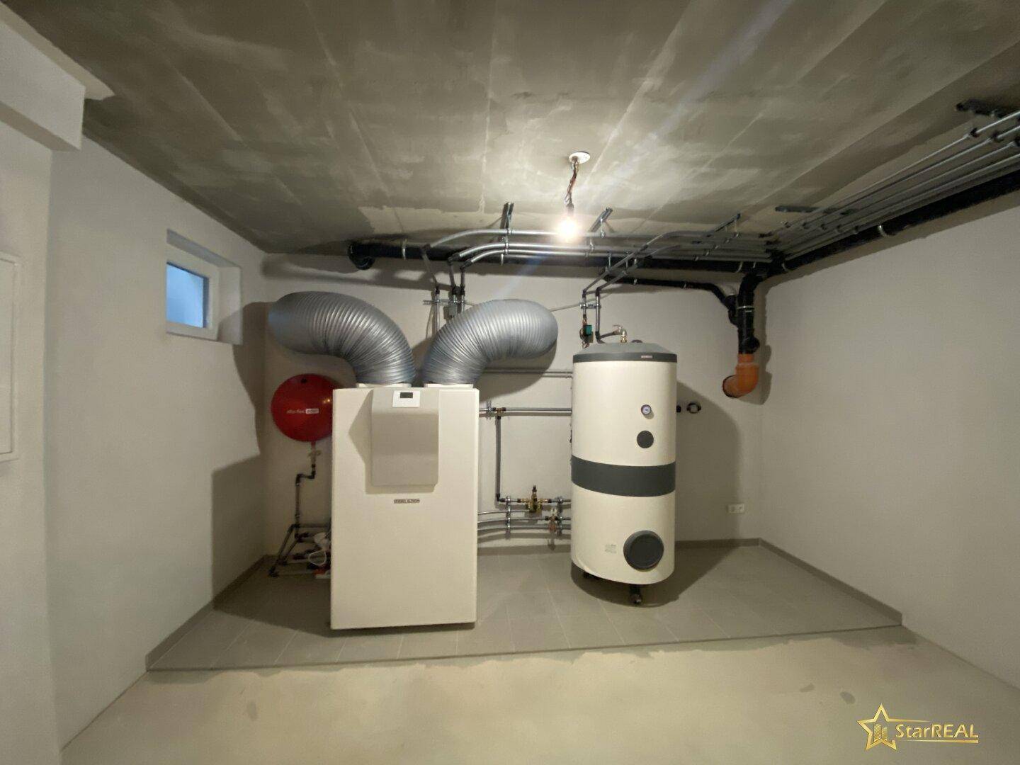Technikraum mit Heizungsanlage und Warmwasserspeicher im Kellergeschoss.