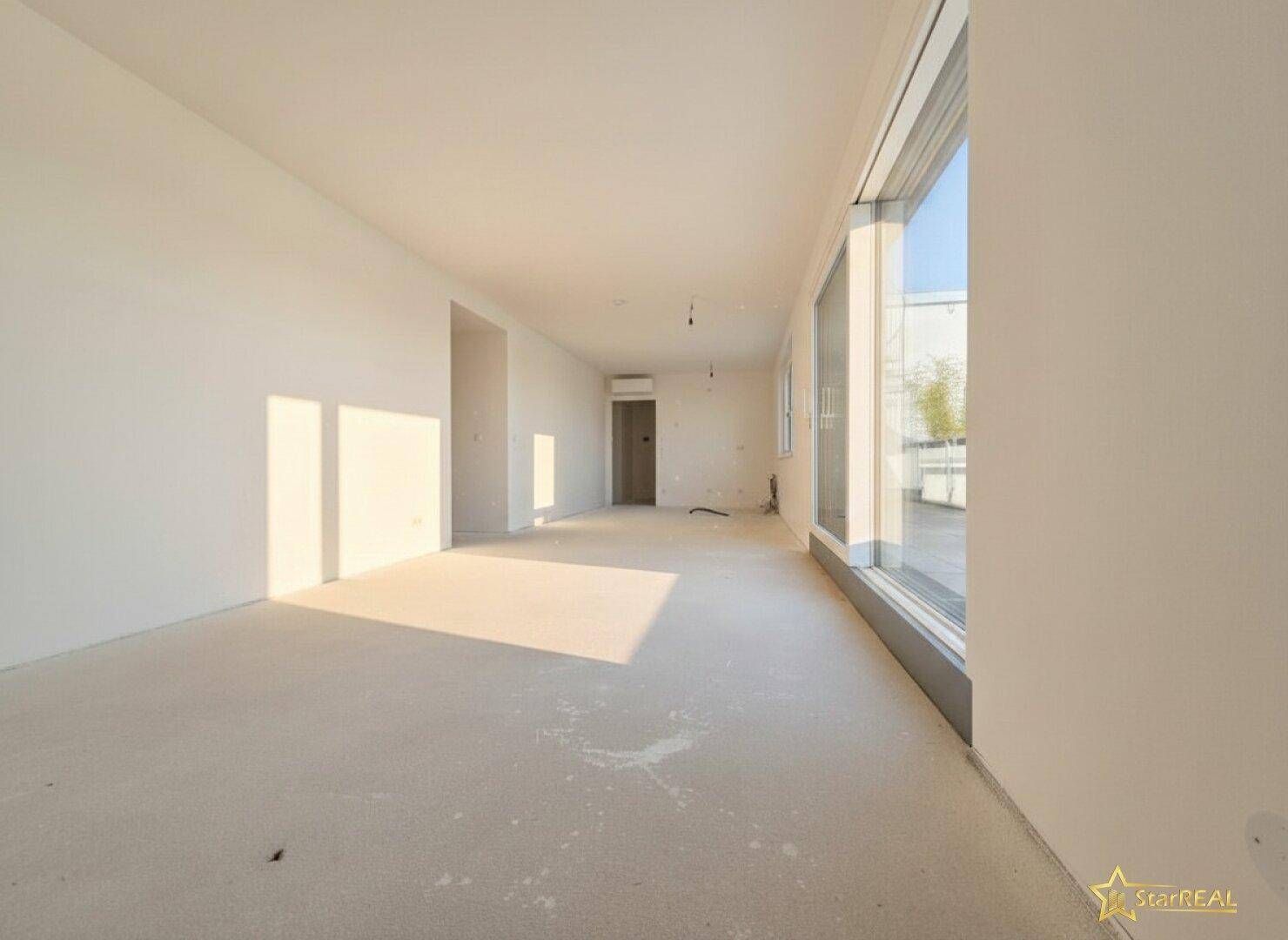 Langer, heller Wohn-Essbereich mit großen Fenstern, die den Blick nach draußen freigeben und viel Licht spenden.