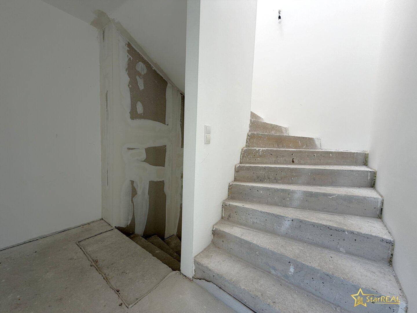 Unfertiger Treppenaufgang im Neubau, der die verschiedenen Etagen des Hauses verbindet.