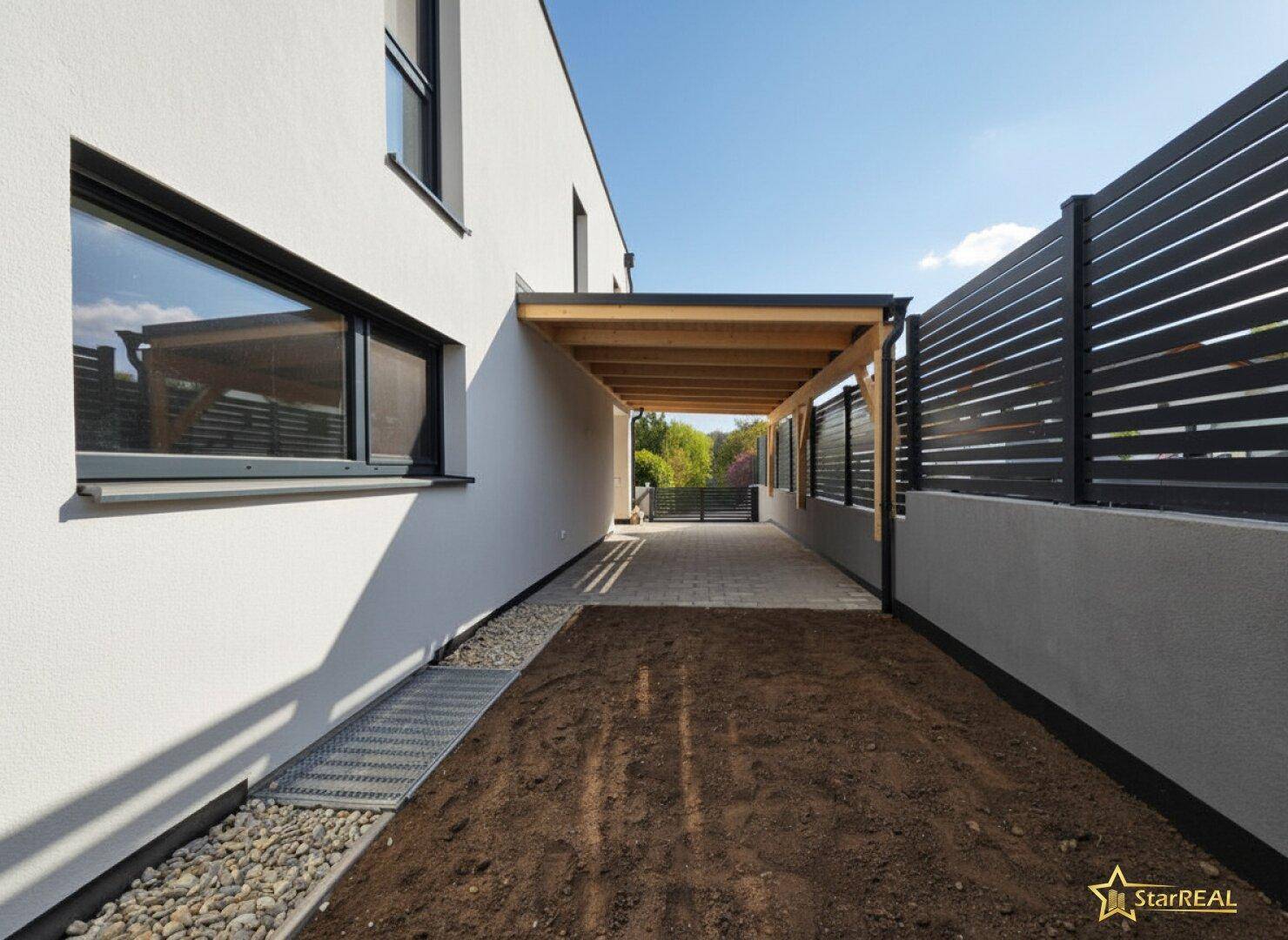Seitenansicht des Hauses mit Carport und Zugang zum hinteren Grundstücksbereich.