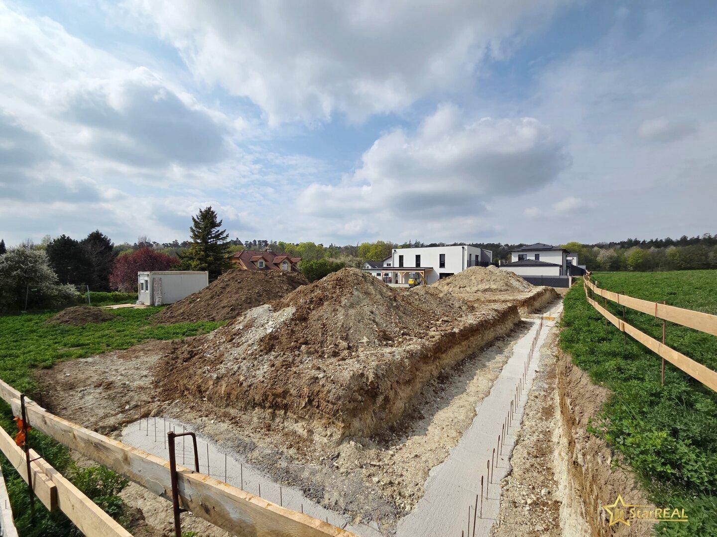 Baustelle mit ausgehobenen Fundamentgräben für ein neues Gebäude.