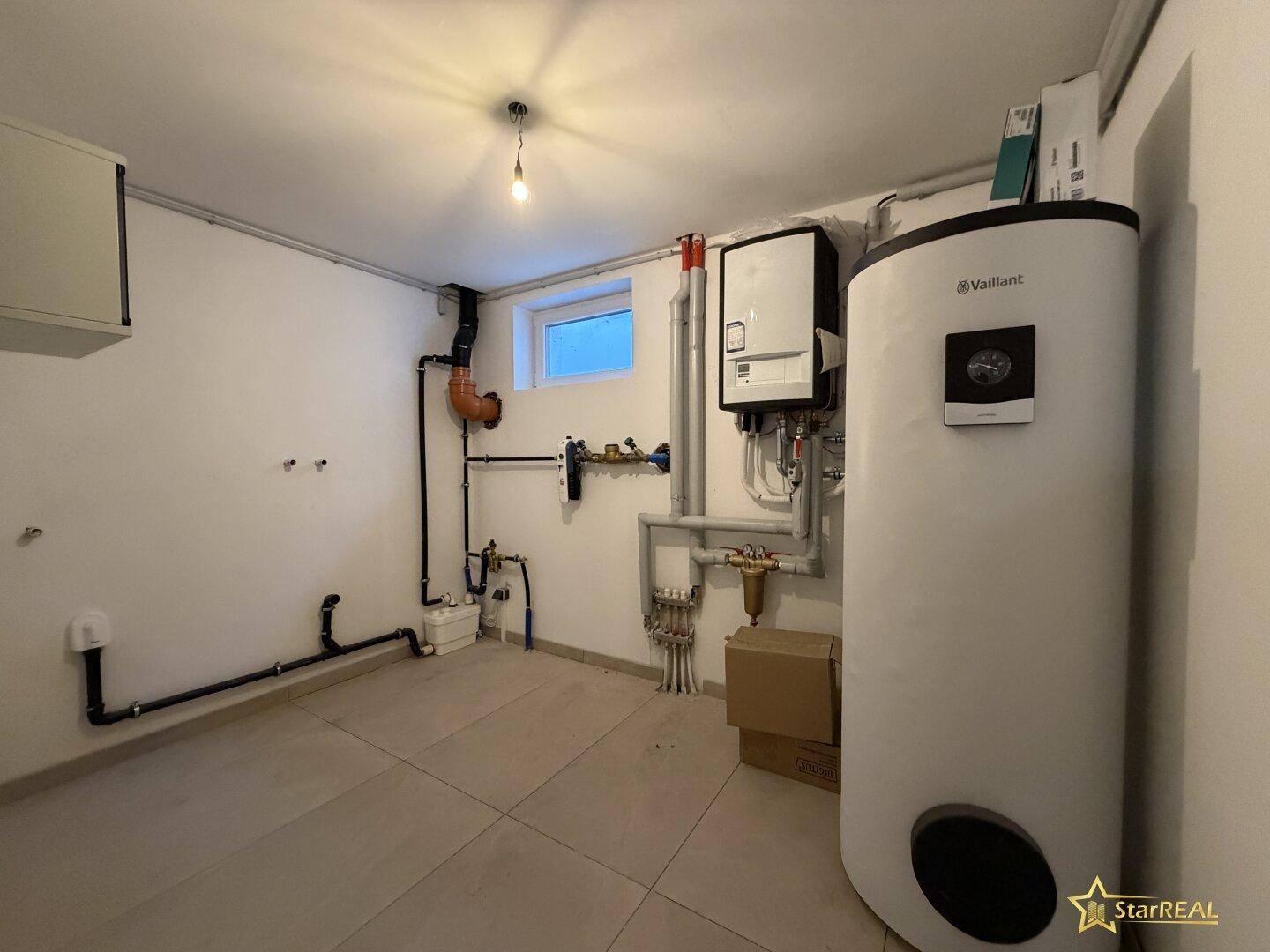 Technikraum im Keller mit moderner Heizungsanlage und Warmwasserspeicher.