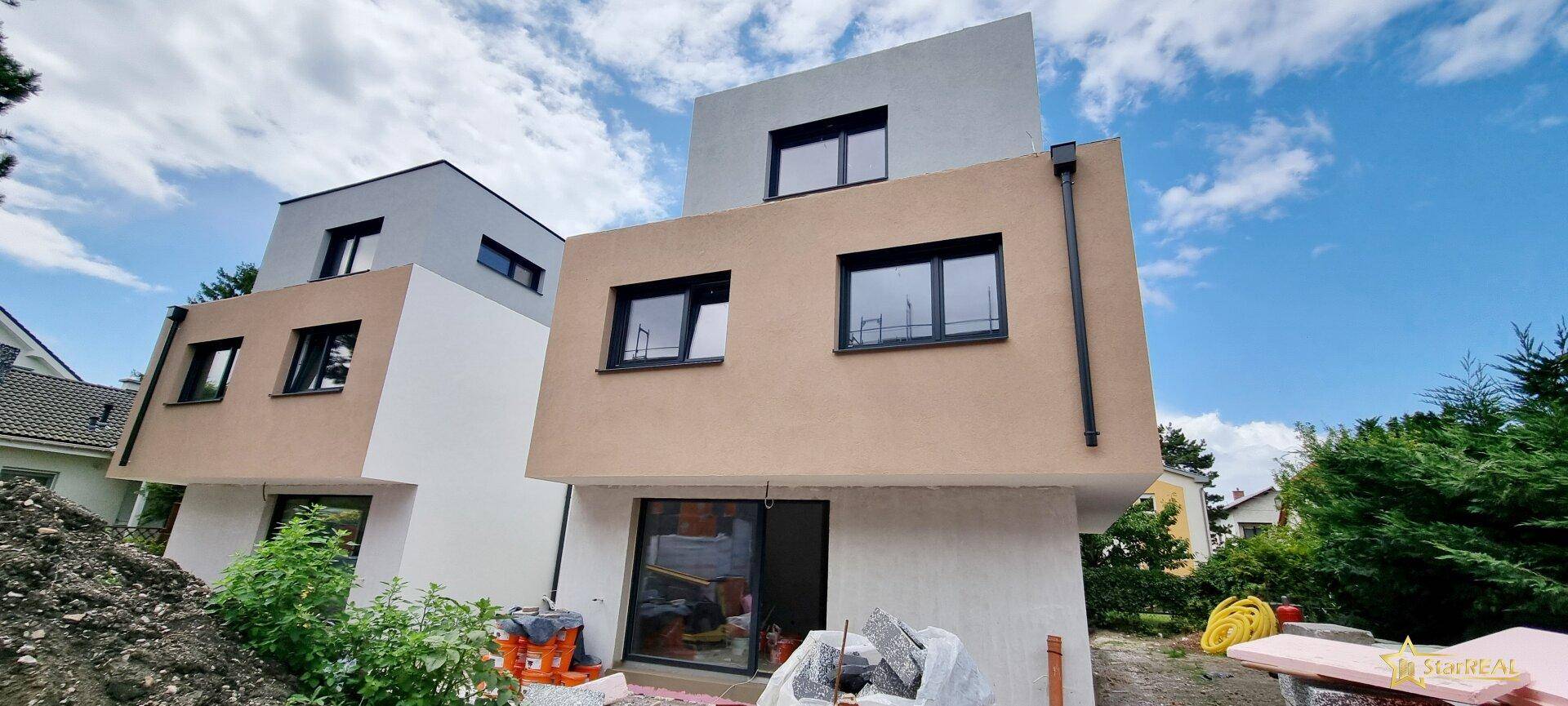 Neubau-Reihenhaus in der Bauphase mit bereits verputzter Fassade.