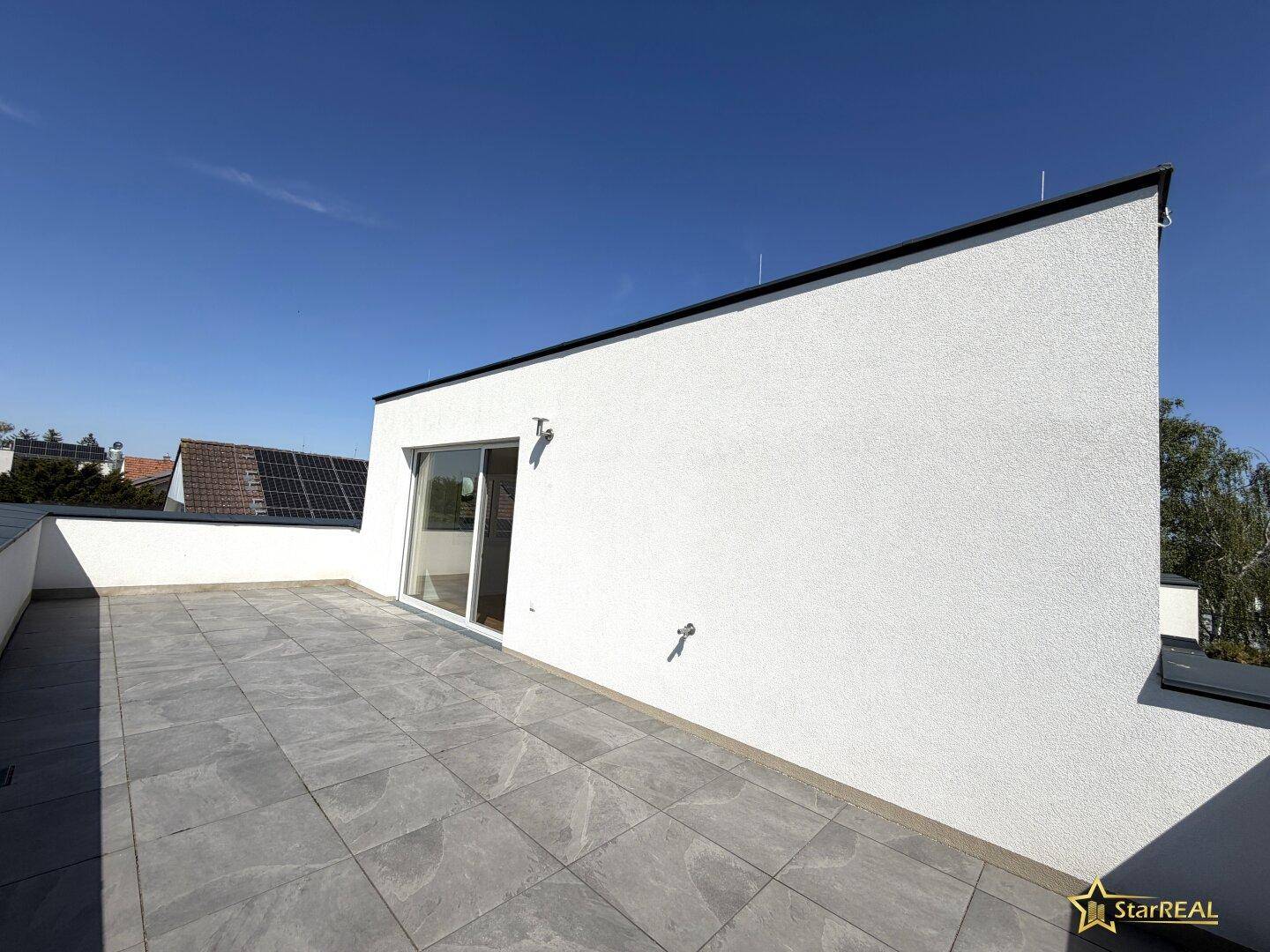 Weitläufige Dachterrasse mit moderner Gestaltung und Blick auf die Umgebung.