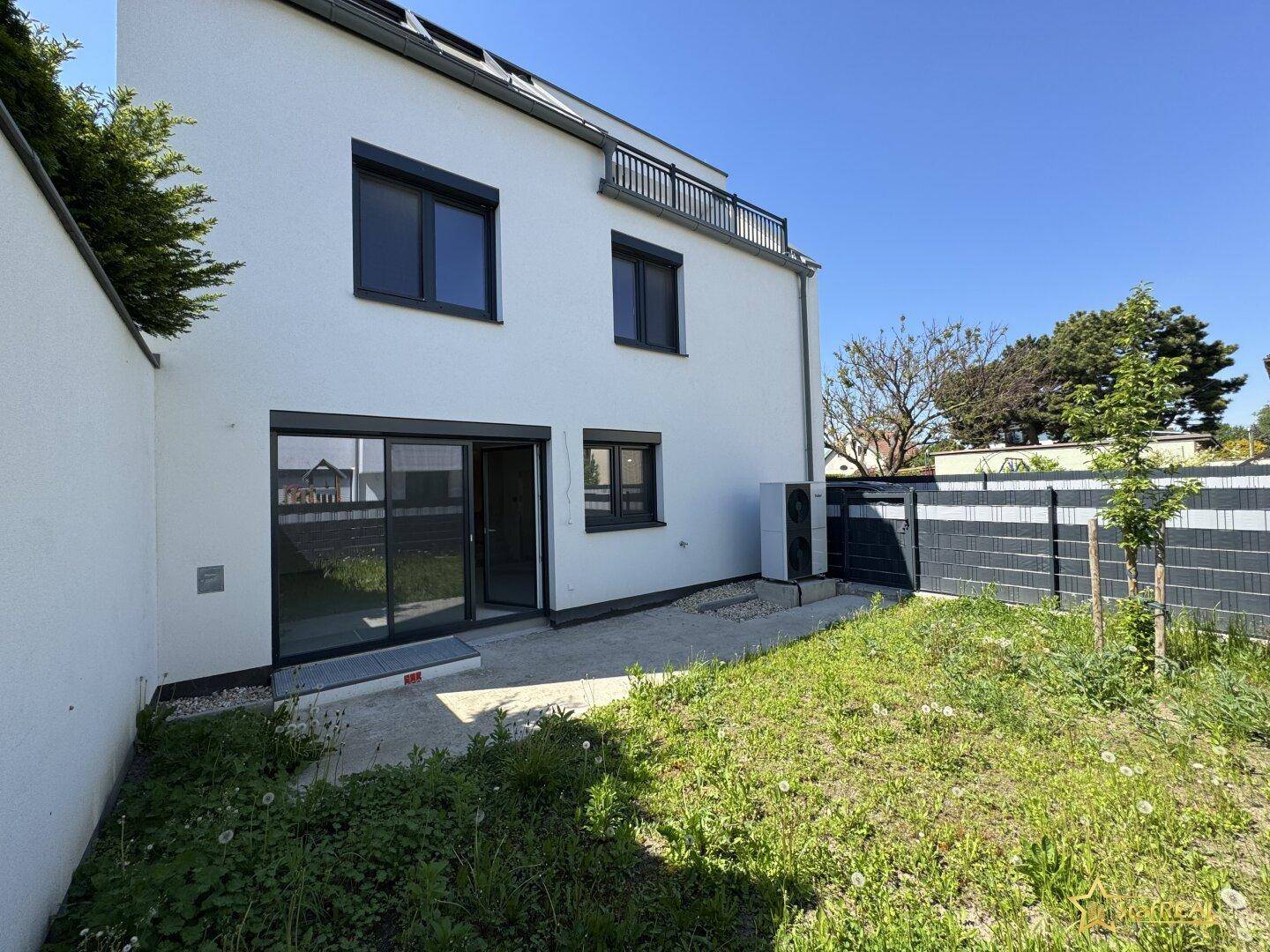 Modernes Haus mit weißer Fassade, Gartenbereich und Terrasse, bereit zur Gestaltung.