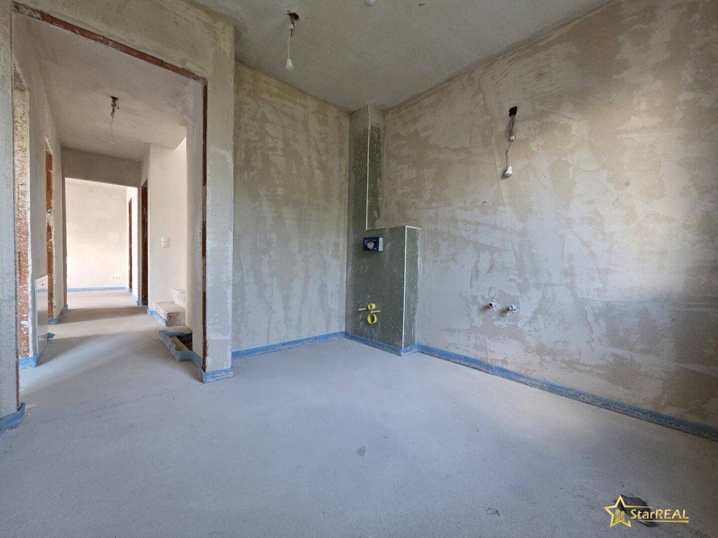 Unfertiger Raum mit sichtbaren Leitungen, bereit für die Küchen- oder Badinstallation.
