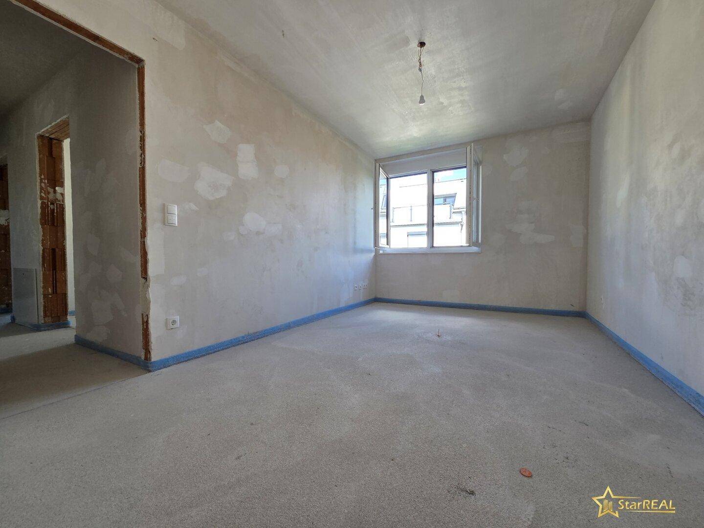 Unfertiges Zimmer mit Fenster, ideal für individuelle Gestaltung.