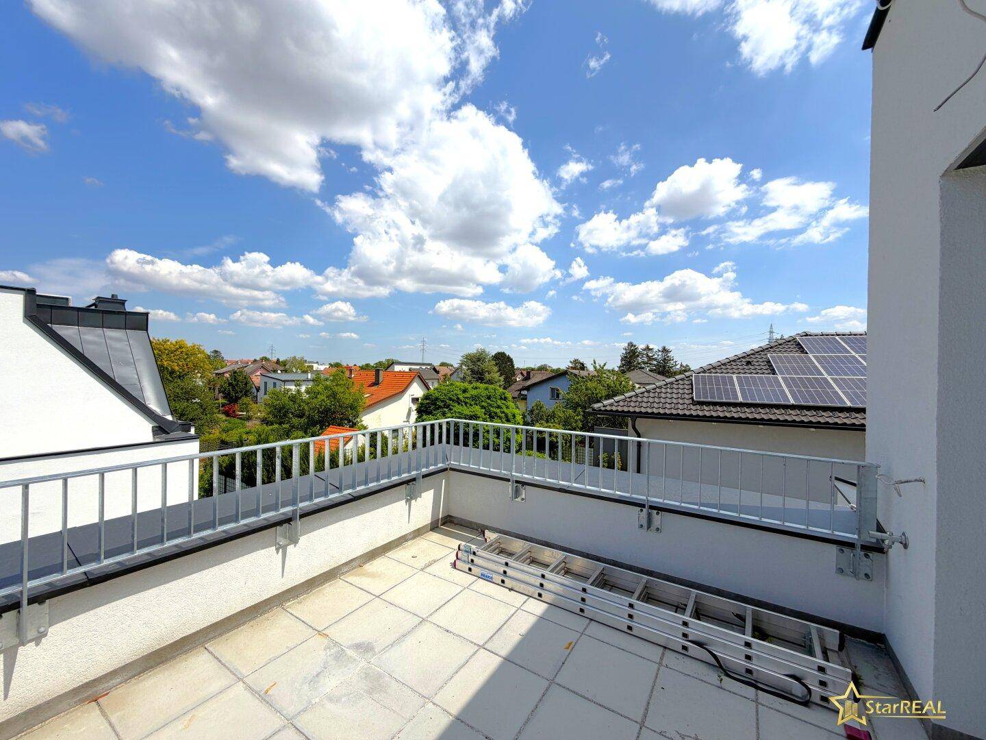 Sonniger Dachterrasse mit weitem Blick über die Dächer und die grüne Umgebung.