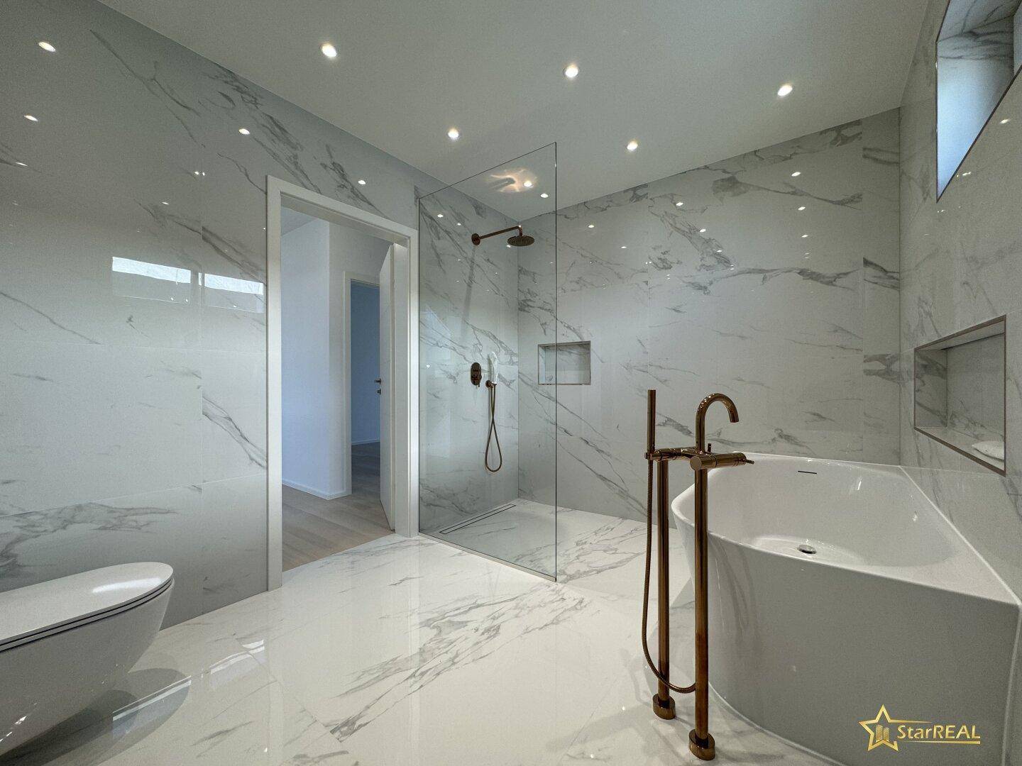 Luxuriöses Badezimmer mit Marmorfliesen, freistehender Badewanne und begehbarer Dusche.
