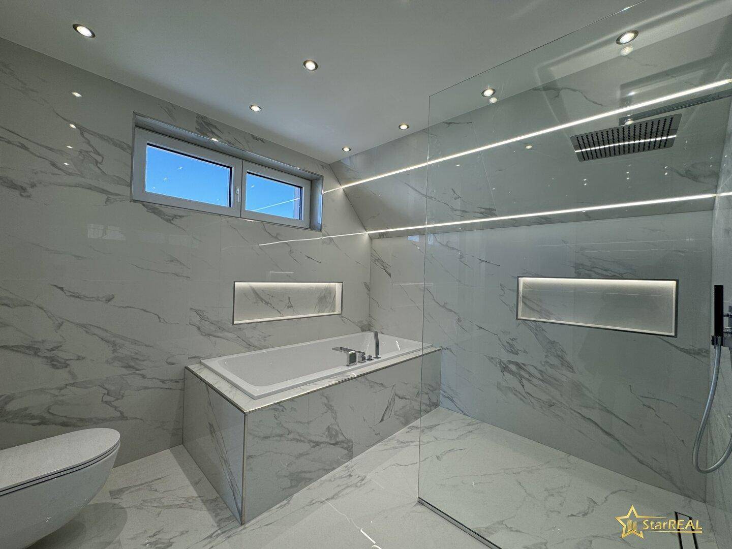 Elegantes Badezimmer mit eingebauter Badewanne, begehbarer Dusche und Marmorfliesen.