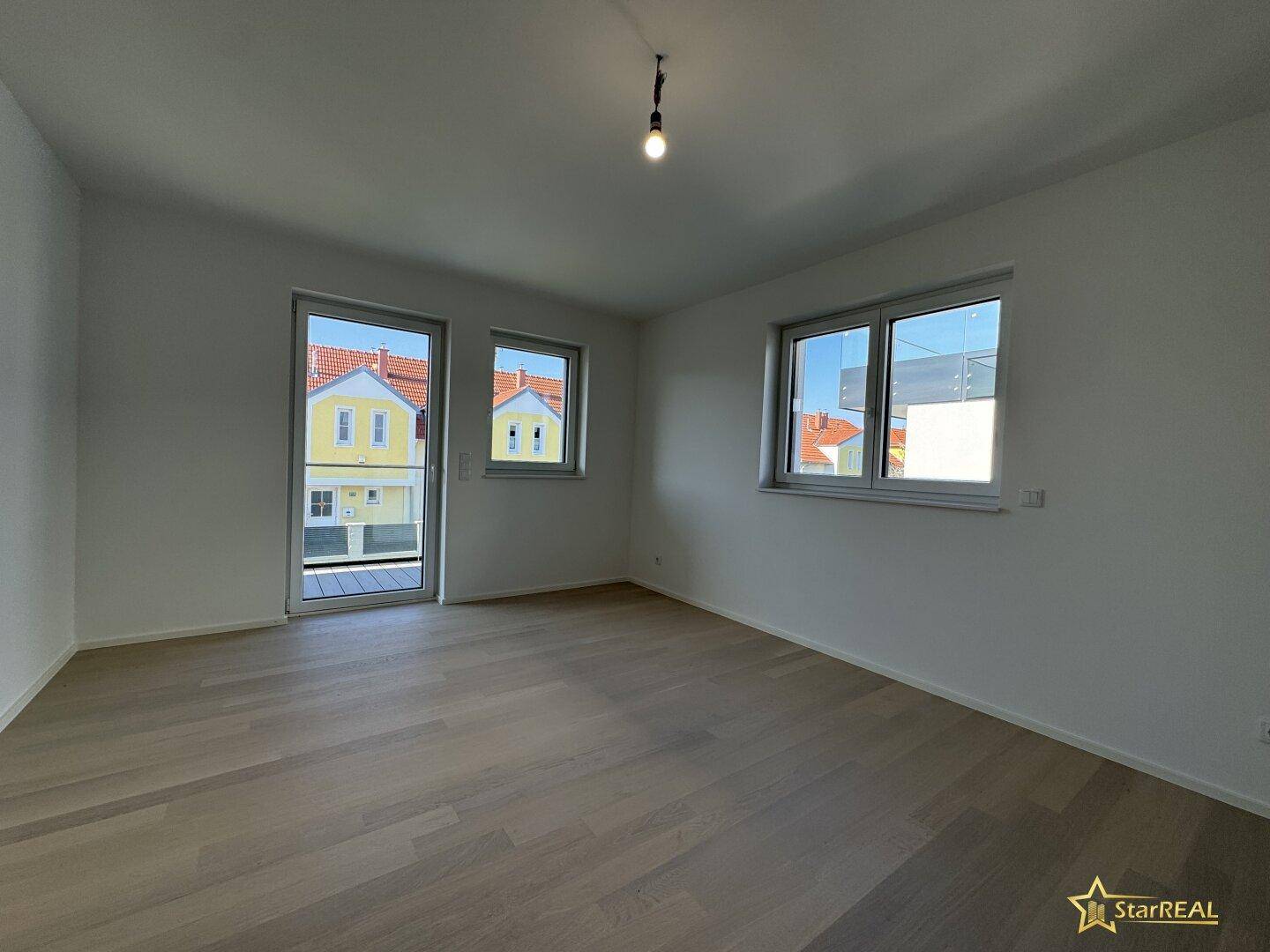 Helles Schlafzimmer mit Parkettboden und Zugang zu einem kleinen Balkon oder französischen Balkon.
