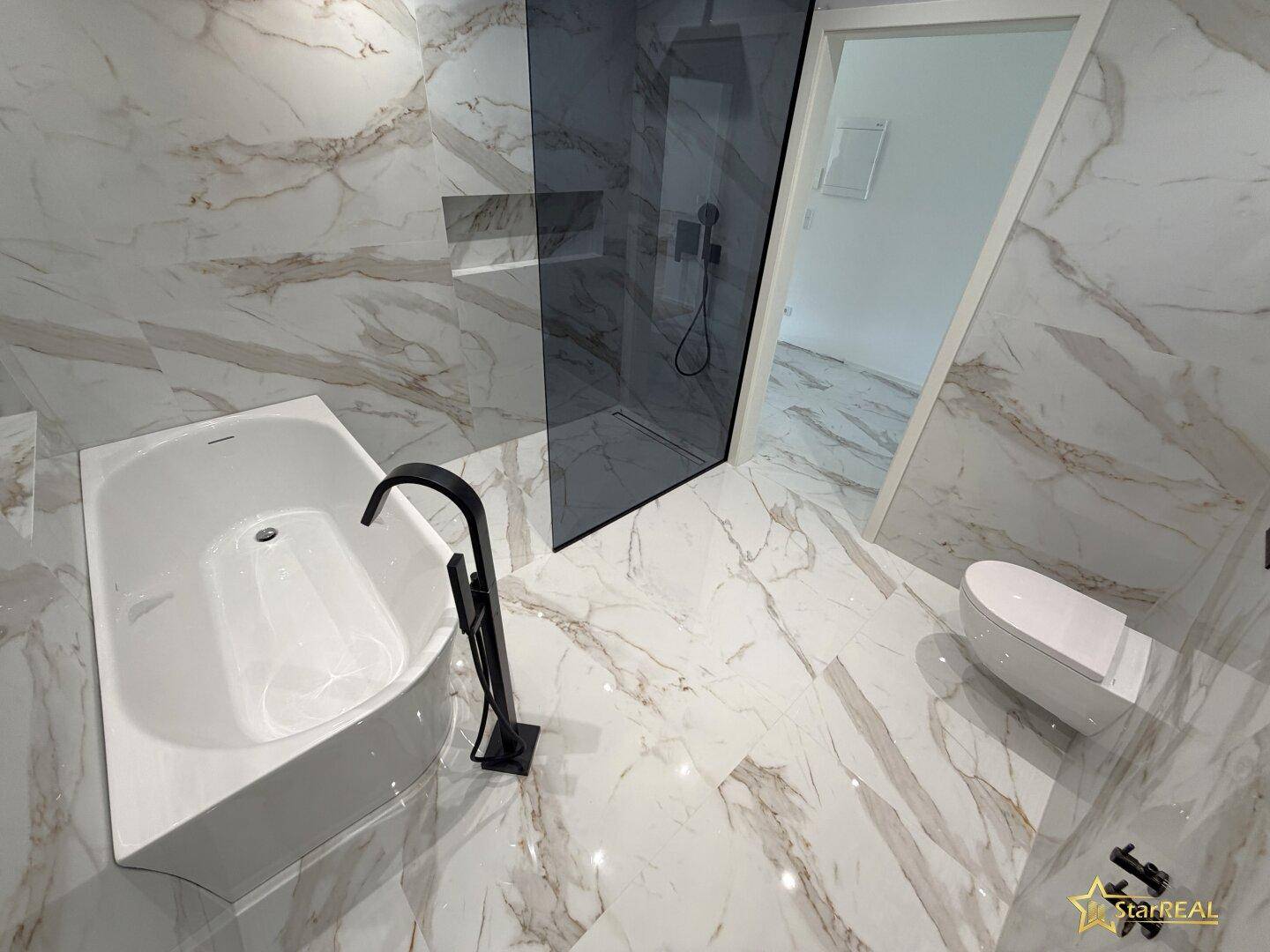 Elegantes Badezimmer mit freistehender Badewanne, begehbarer Dusche und luxuriösen Marmorfliesen.