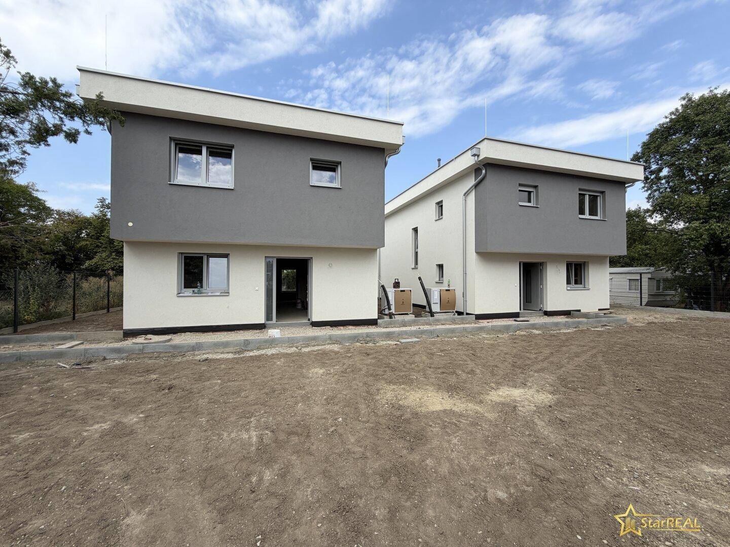 Ansicht von zwei modernen Neubauten mit klaren Linien und großen Fensterfronten.
