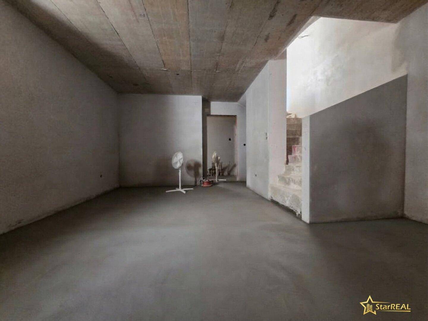 Kellerraum im Rohbau mit Betonboden und -decke, bereit für die weitere Nutzung.