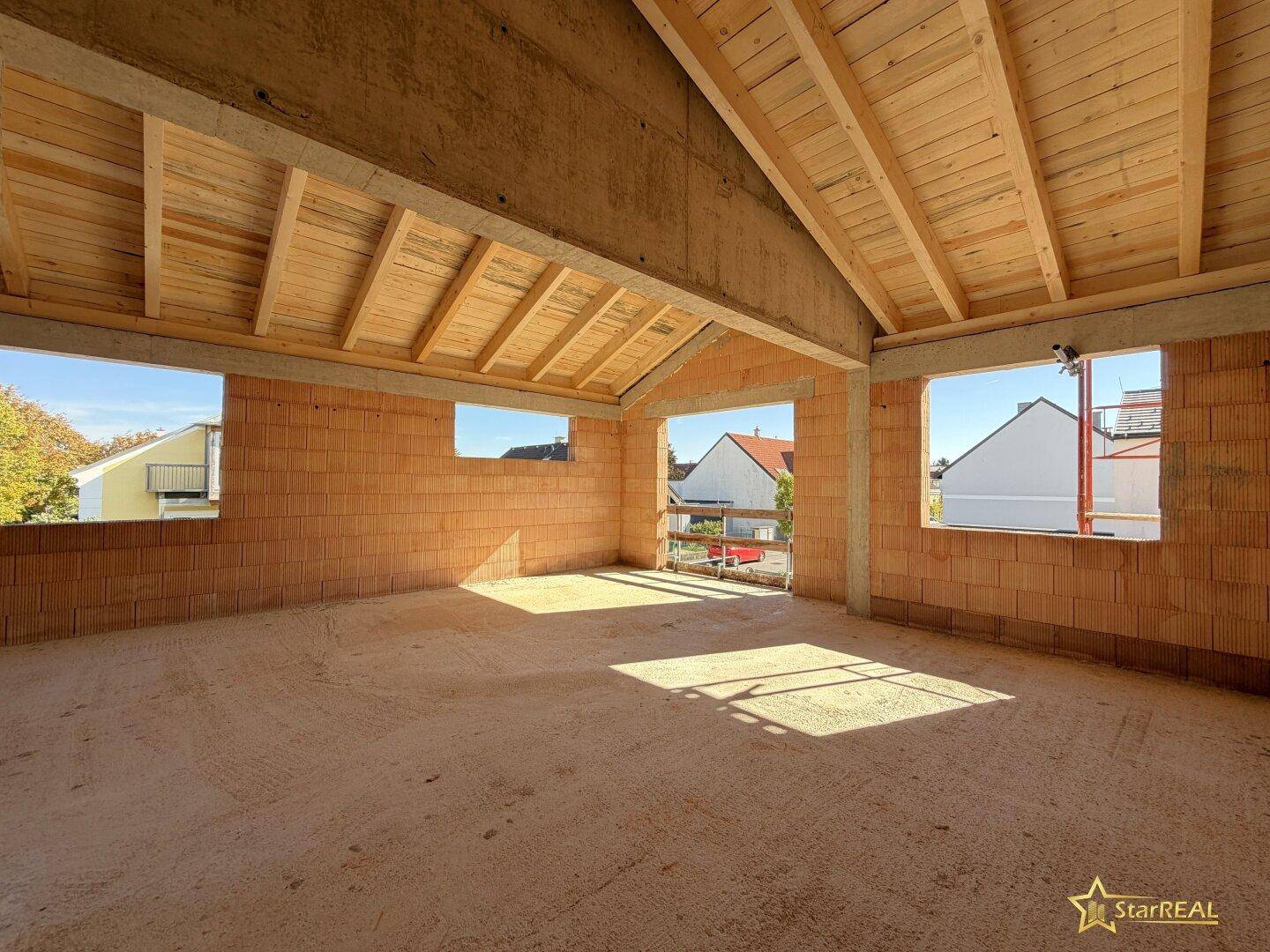 Geräumiger Raum im Obergeschoss mit Holzdach und Ziegelwänden, ideal für individuelle Gestaltung.