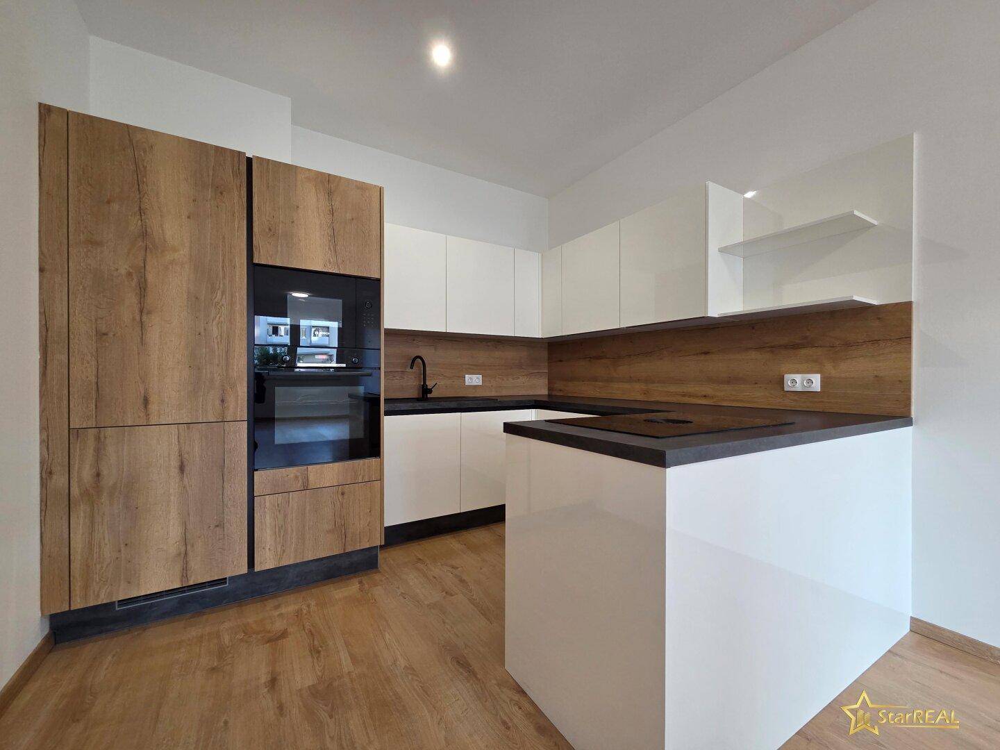 Moderne Einbauküche mit weißen Hochglanzfronten, Holzdekor und integriertem Backofen.