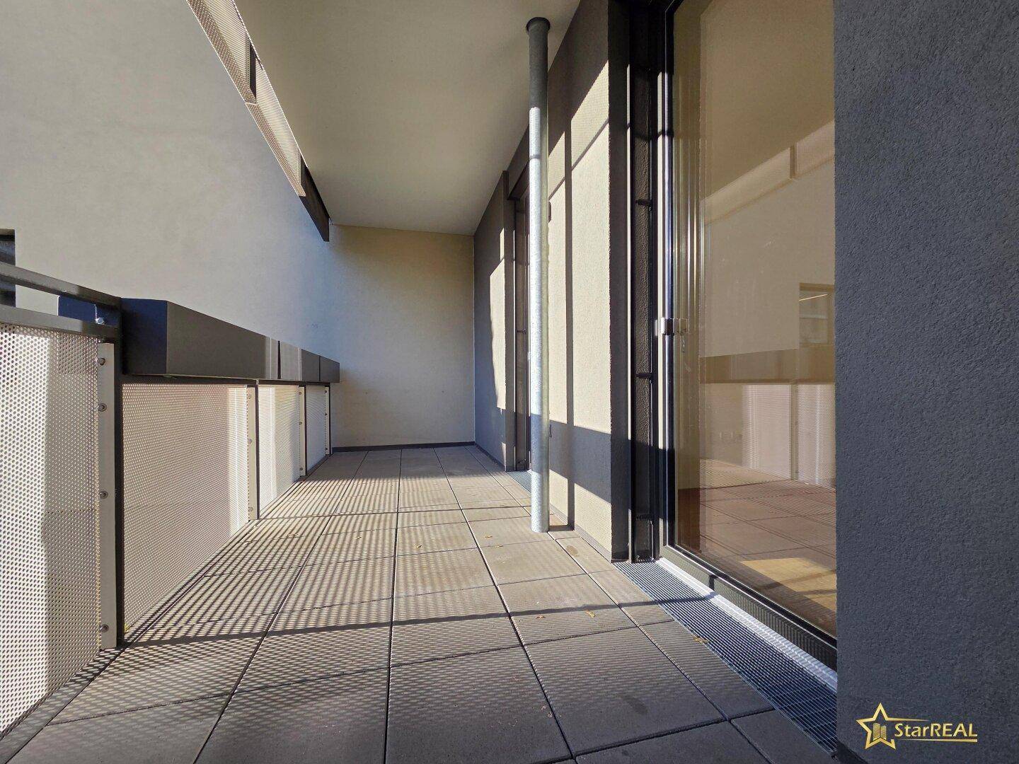 Langer, gefliester Balkon mit moderner Metallbrüstung, ideal für entspannte Stunden im Freien.