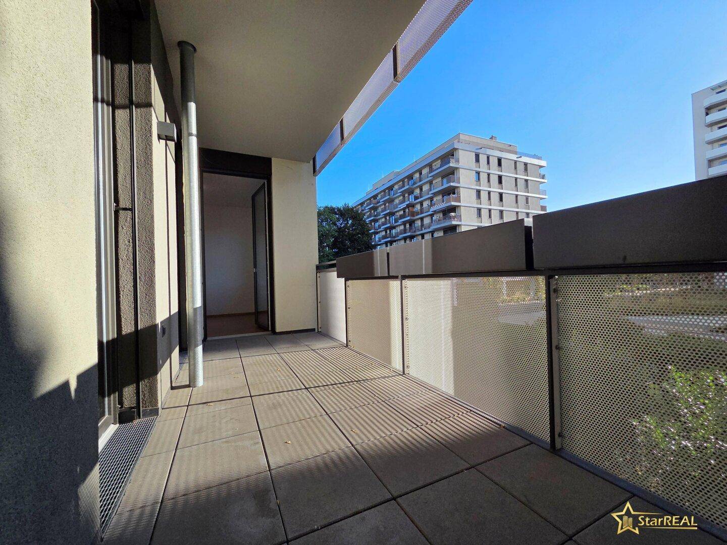 Geräumiger Balkon mit Fliesenboden und moderner Brüstung, bietet einen weiten Blick auf die Umgebung.