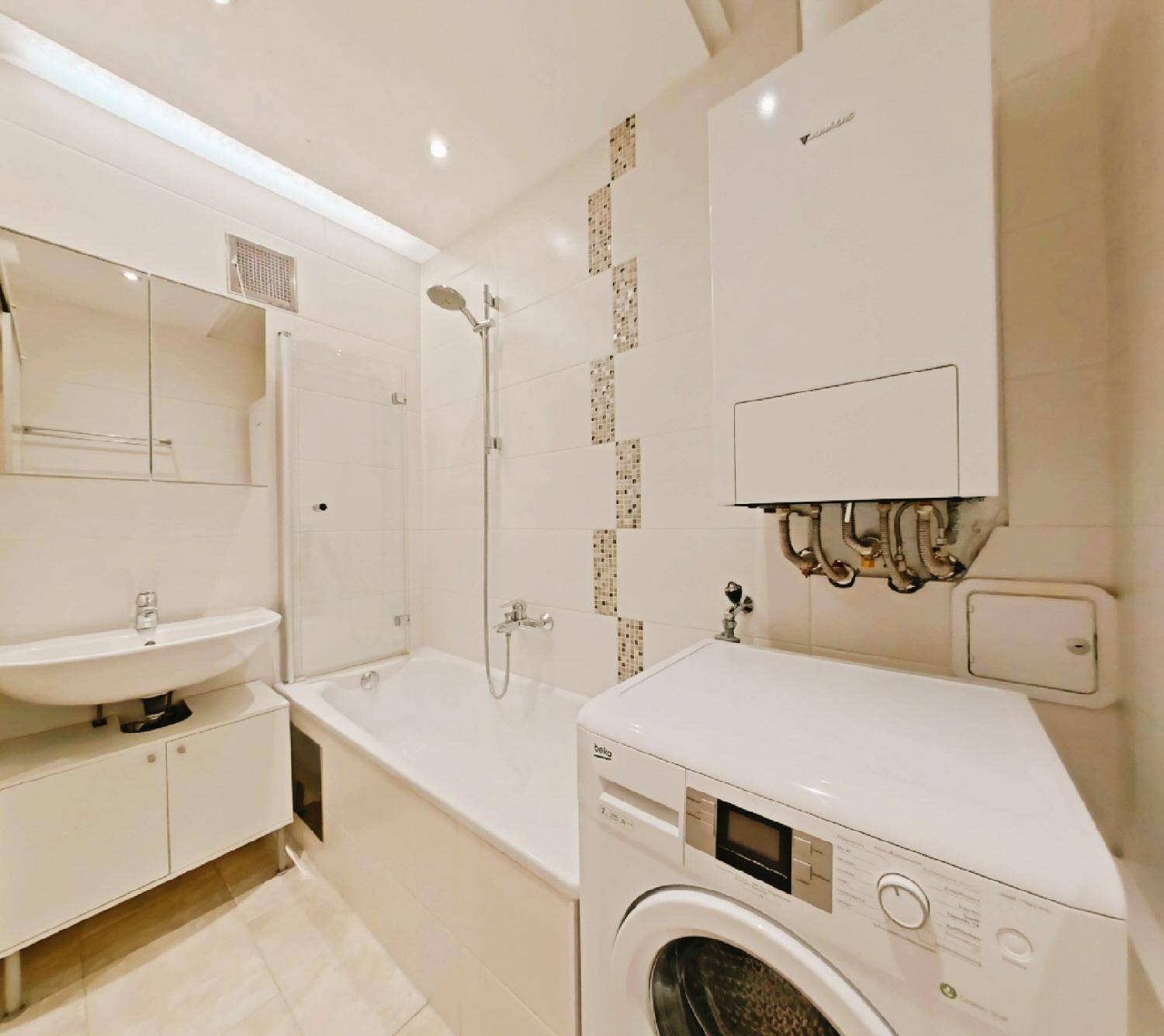 Modernes Badezimmer mit Badewanne, Dusche, Waschbecken und Waschmaschine.