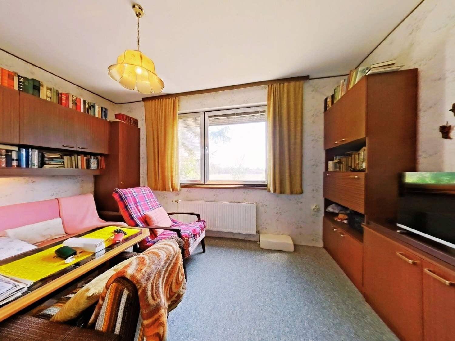 Schlafzimmer oder Gästezimmer mit Teppichboden, Einbauschränken und Fenster.