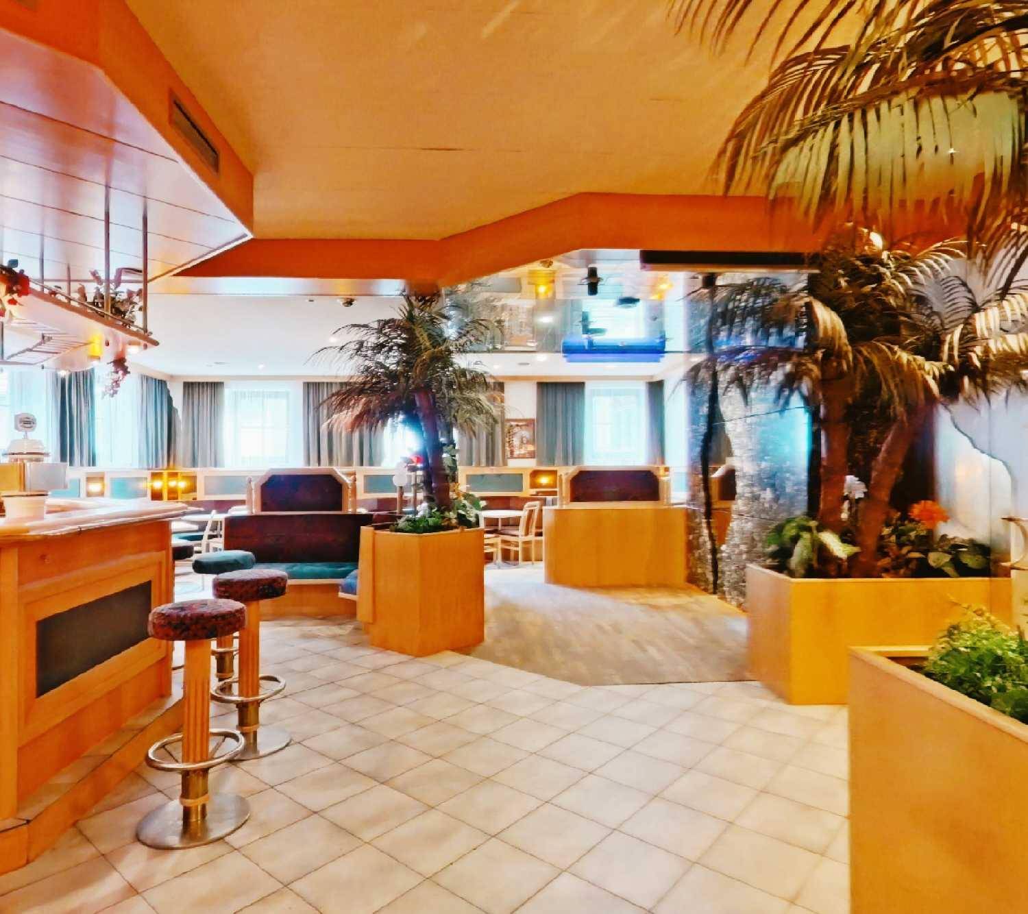 Restaurantbereich mit Bar, Sitzgelegenheiten und dekorativen Pflanzen, ideal für Gastronomiebetriebe.