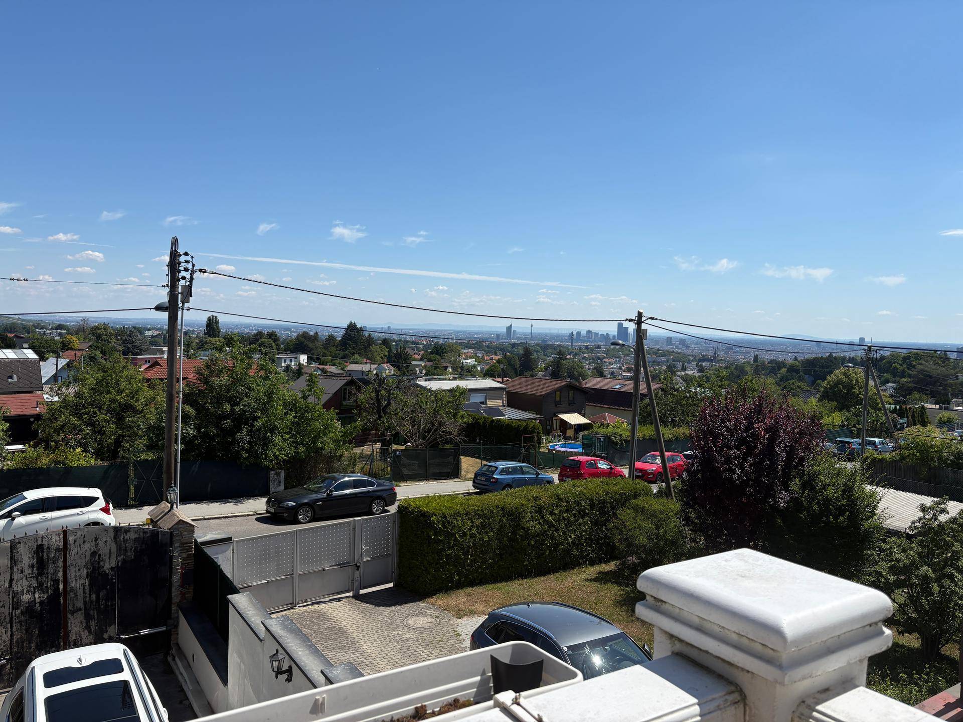 Weitläufiger Ausblick über die Stadt und die grüne Umgebung unter einem klaren blauen Himmel.