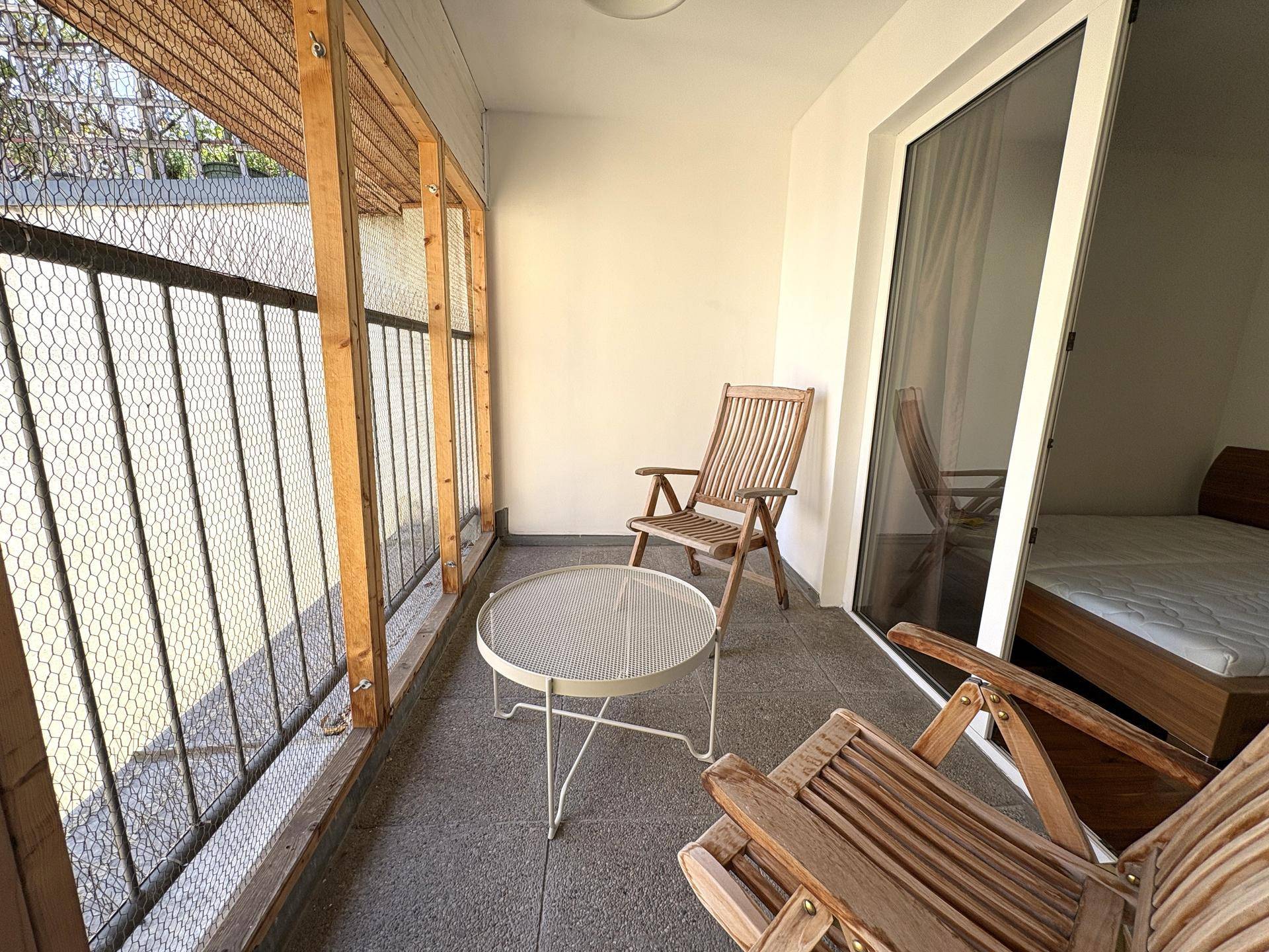Heller Balkon mit Sitzgelegenheiten und Zugang vom Schlafzimmer, bietet einen angenehmen Außenbereich.